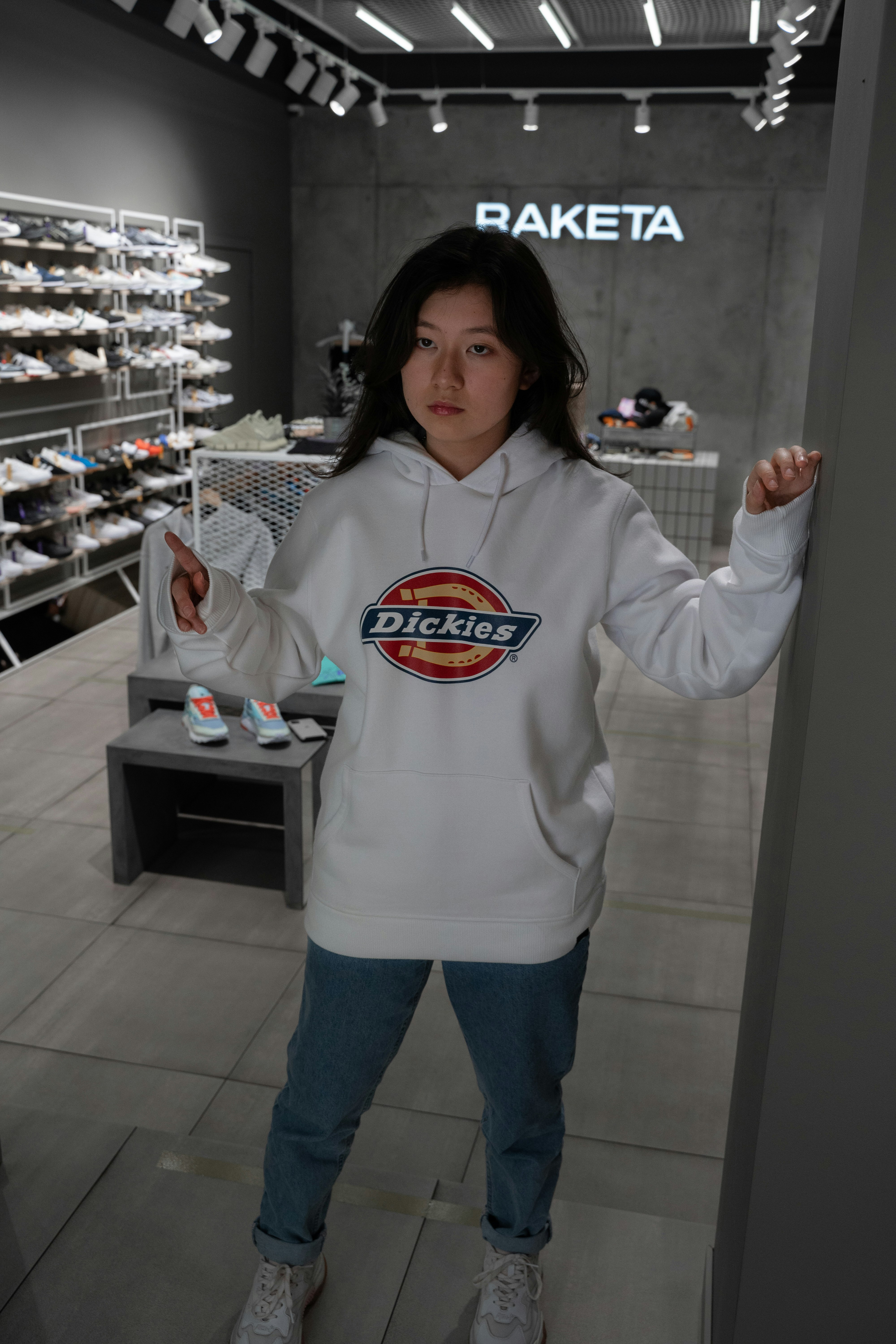 woman in white hoodie standing near counter